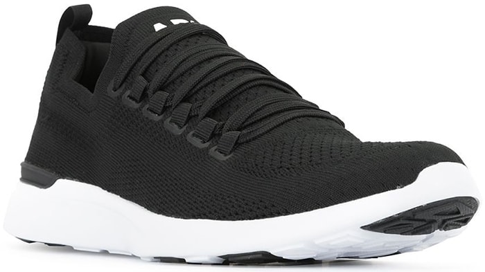 Black and white TechLoom Breeze sneakers from APL: Athletic Propulsion Labs featuring a round toe, a lace-up front fastening, a mesh upper, a logo patch at the tongue, a padded ankle, a pull tab at the rear, a flat rubber sole, and proprietary Propelium technology