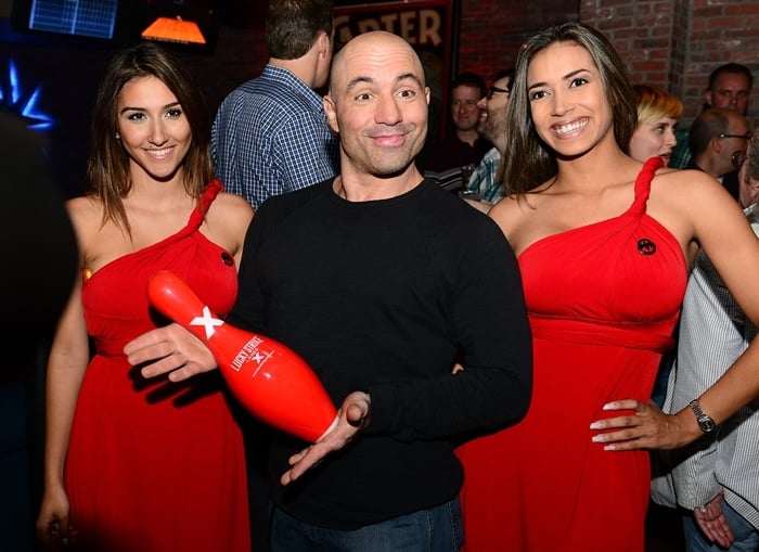 Joe Rogan enjoys the company of two young women at the South Beach Comedy Festival opening night party