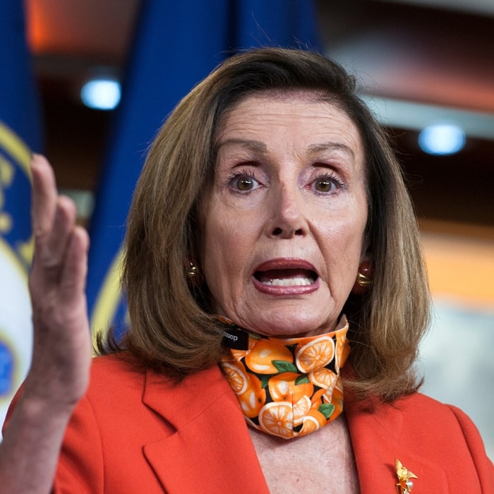 Nancy Pelosi wears an orange print scarf with a red jacket