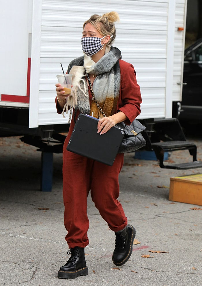 Pregnant Hilary Duff hides her baby bump in a red jumpsuit on the set of Younger in New York City on October 22, 2020