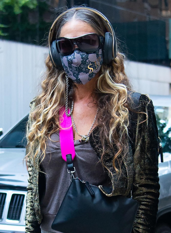 Sarah Jessica Parker wears headphones and lace face mask with her initials in gold lettering