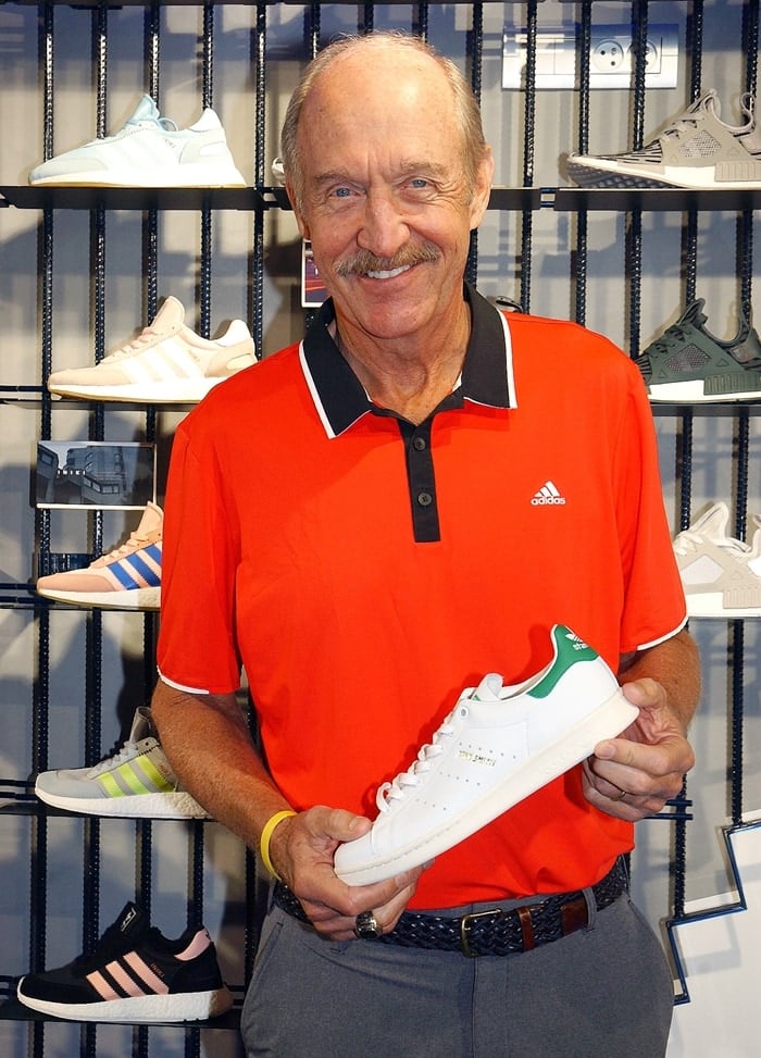 Former world No. 1 American tennis player and two-time Grand Slam singles champion Stan Smith holding a pair of Adidas Stan Smith sneakers