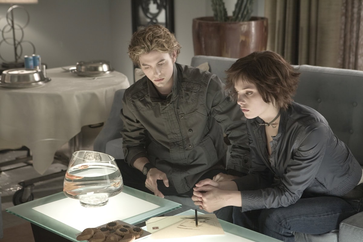 Ashley Greene as Alice Cullen and Jackson Rathbone as Jasper Hale appear deeply concentrated while strategizing in a scene from the "Twilight" saga