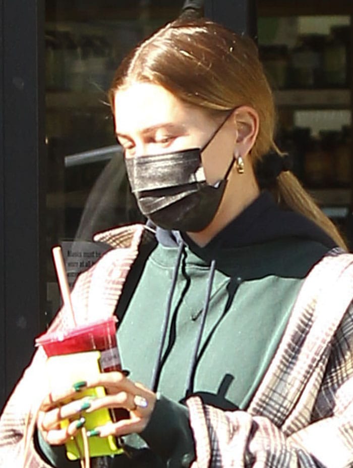 Hailey Bieber wears a bare-faced look with a black face mask for protection against COVID-19