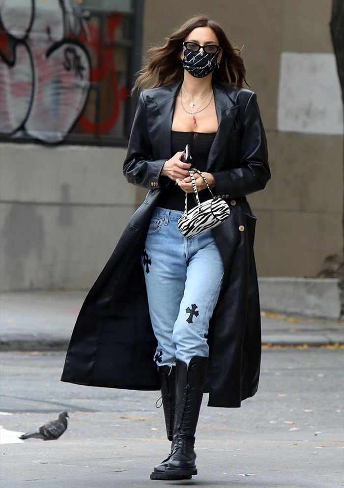 Irina Shayk looks chic in Nanushka black faux leather trench coat, black corset, and patchwork jeans