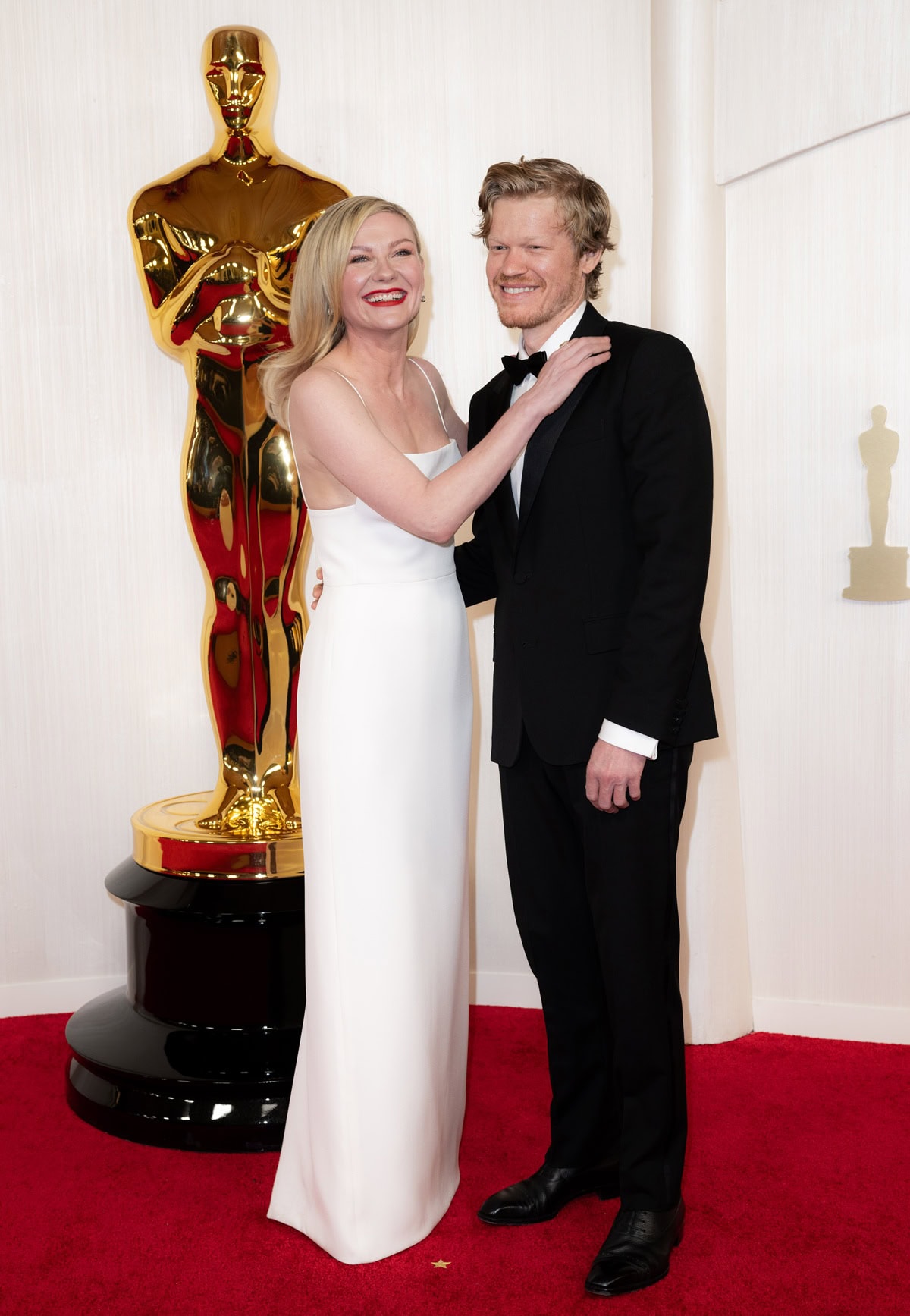 Kirsten Dunst and Jesse Plemons exude timeless elegance at the 2024 Academy Awards, where she stunned in a minimalist white Gucci gown and classic red lip