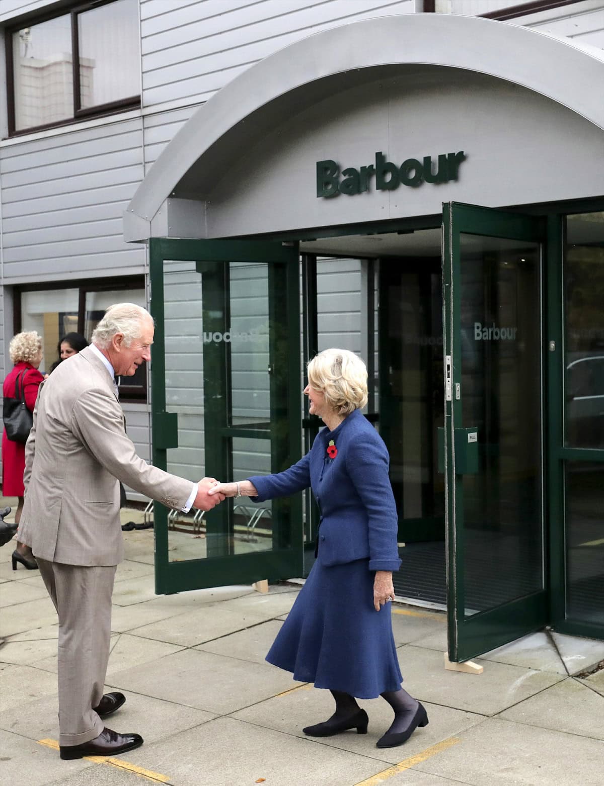 Prince Charles, the Prince of Wales, greets Dame Margaret Barbour during a tour of J. Barbour & Sons Ltd. in Tyne and Wear on November 9, 2021, highlighting the brand’s royal heritage and continued excellence in British manufacturing