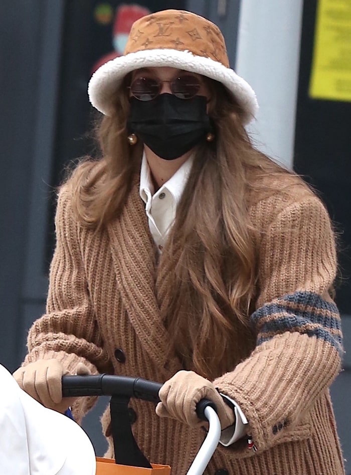 Gigi Hadid goes monochromatic as she pairs her quilted coat with a beige Louis Vuitton shearling-lined bucket hat