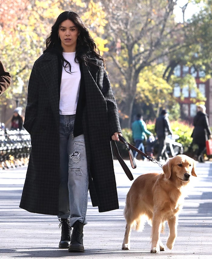 Hailee Steinfeld wears a white tee with ripped jeans and a plaid wool coat