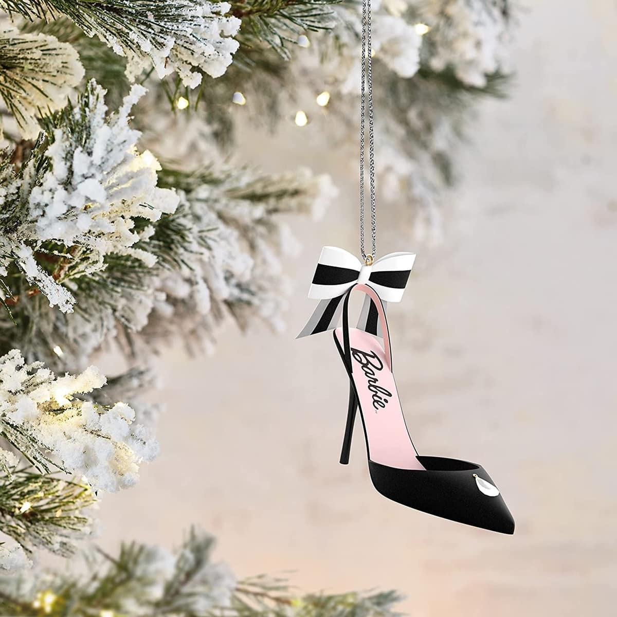 Designed by Debra Nielsen and Matt Johnson, this metal Barbie ornament features fabric ribbon and gem accents