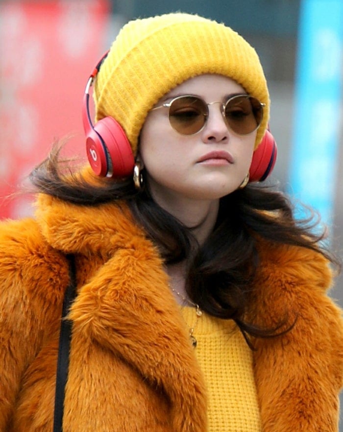 Selena Gomez looks cool with a yellow beanie and red headphones