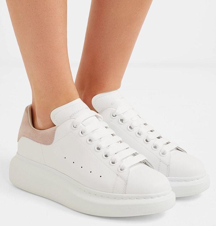 Made from smooth white leather, these Alexander McQueen sneakers are trimmed with pastel-pink suede and rest on the house's signature exaggerated sole