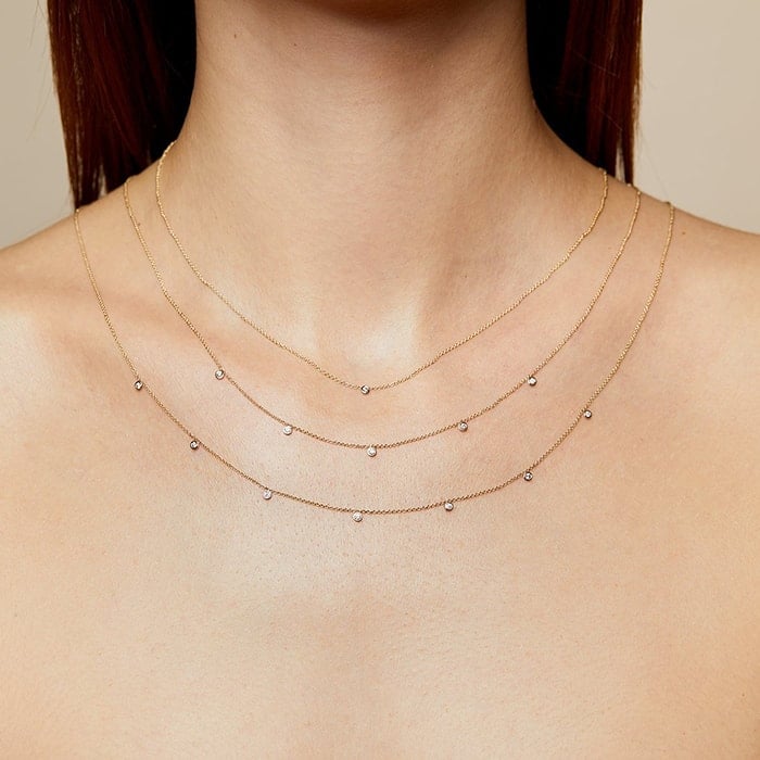 A minimalist ultra-fine chain necklace with five tiny diamonds is a perfect complement to any neckline