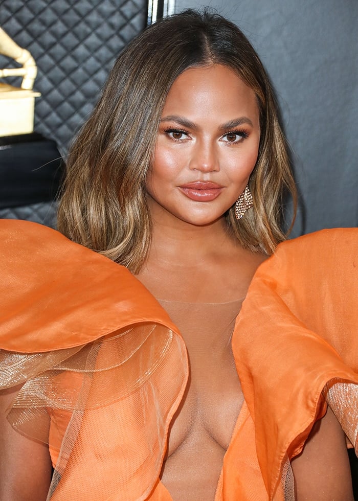 Chrissy Teigen's boobs peeking through her Yanina Couture dress orange dress at the 62nd Annual GRAMMY Awards on January 26, 2020