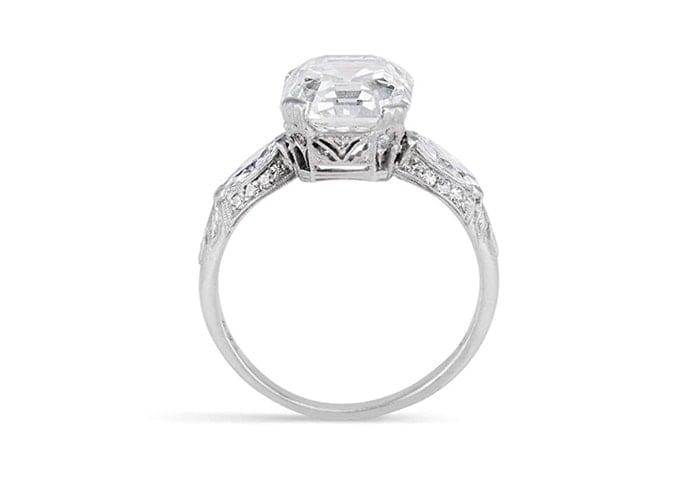 A vintage engagement ring featuring a 4.77-carat elongated asscher-cut diamond with single, marquise-cut diamond shoulders in a platinum band