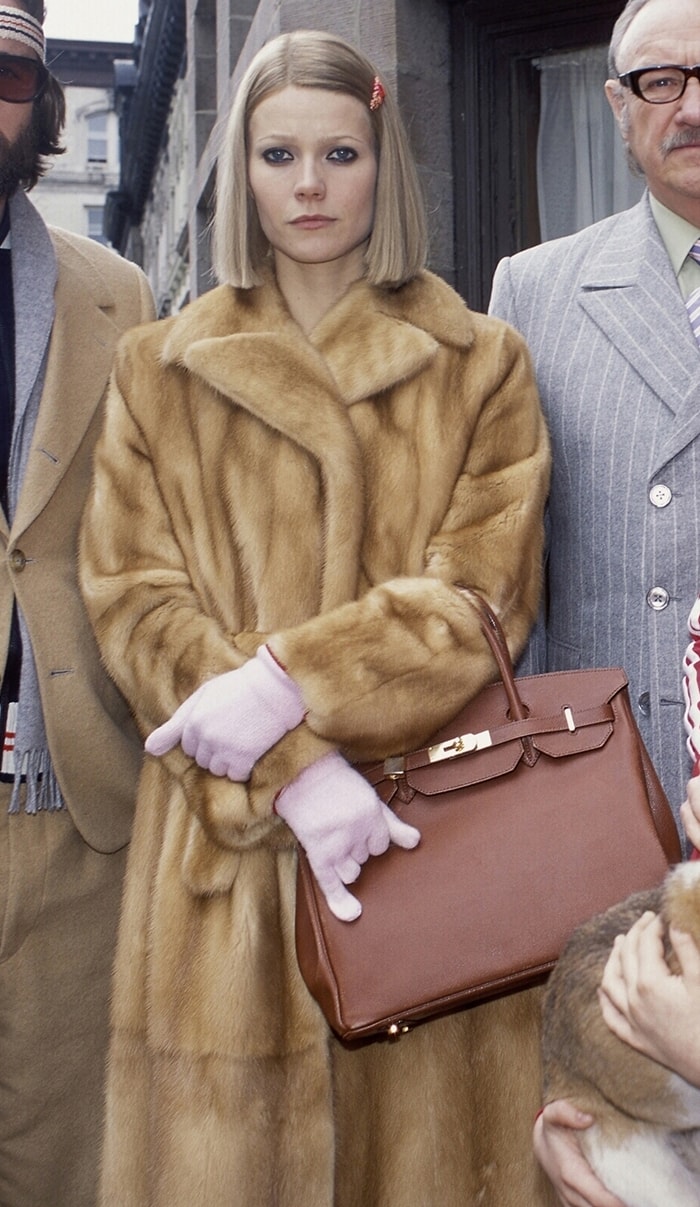 Gwyneth Paltrow as Margot Tenenbaum in The Royal Tenenbaums wearing a luxurious fur coat and carrying a Hermès Birkin bag, capturing the character's iconic style