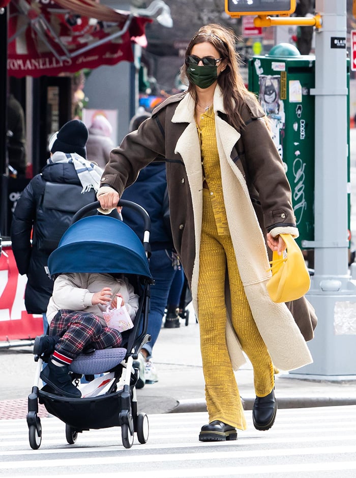 Irina Shayk pairs her coat with a loungewear-inspired Live the Process yellow cardigan and flare pants