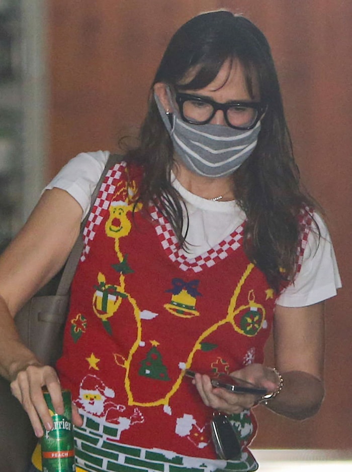 Jennifer Garner wearing thick, black-framed specs with gray-and-white striped face mask