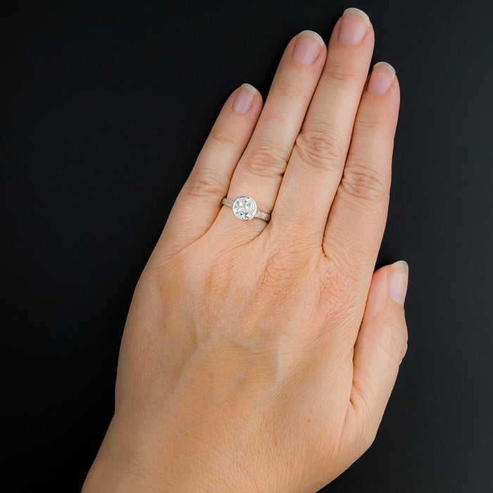 A 1.65-carat bright white European cut diamond sparkles from within the platinum bezel and refined Edwardian solitaire mounting