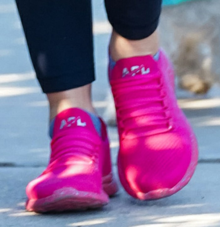 Lucy Hale adds color to her dark-themed hiking look with APL hot pink sneakers