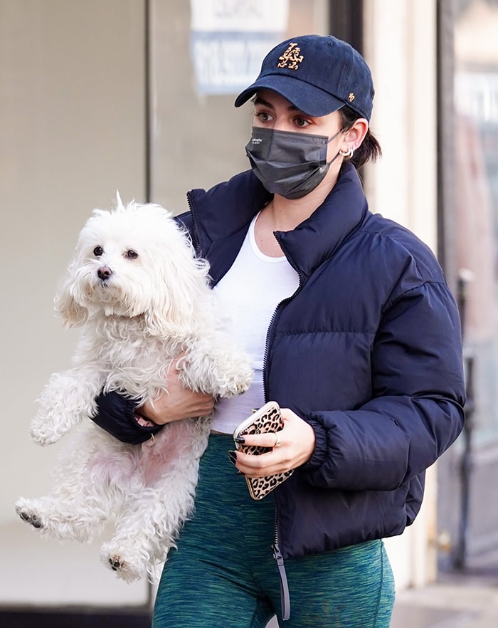 Lucy Hale styles her look with LA Dodgers cap as she grips her iPhone Pro Max in Casetify leopard-print casing