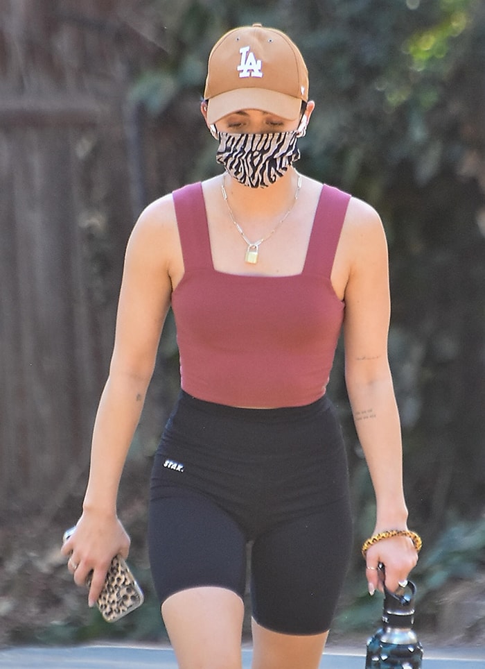 Lucy Hale shows her penchant for animal prints with zebra face mask and leopard bangle and phone case