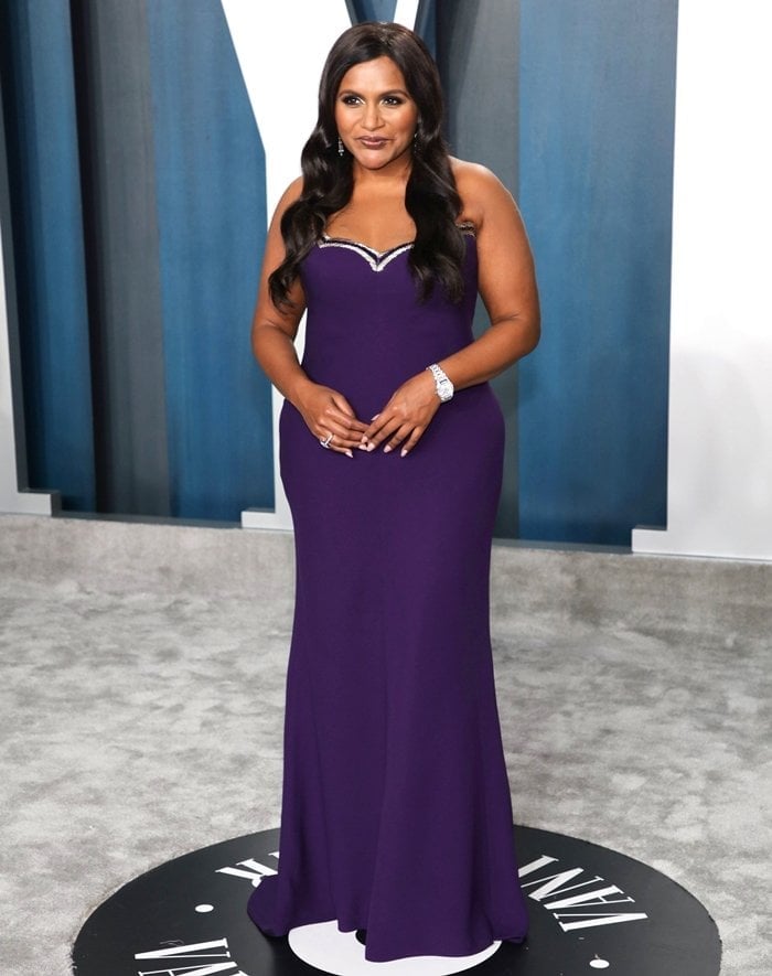 Mindy Kaling stuns in a violet Reem Acra dress and Chopard jewelry while arriving for the 2020 Vanity Fair Oscar Party