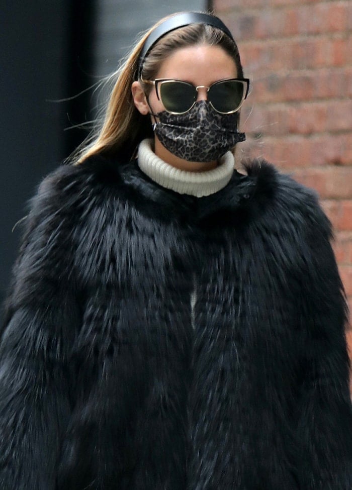 Olivia Palermo keeps it chic with a black headband, cat-eye sunnies, and leopard-print face mask