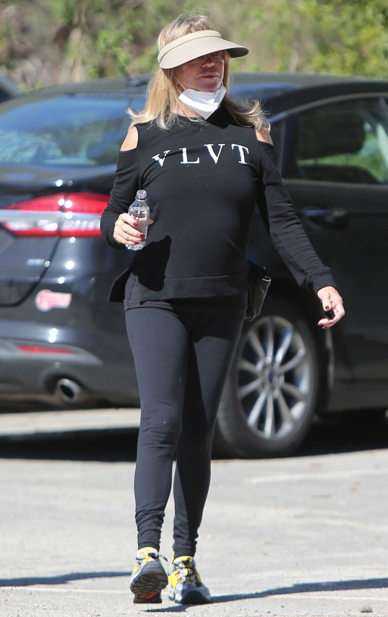 Goldie Hawn goes hiking in leggings and a "VLVT" black cold-shoulder top