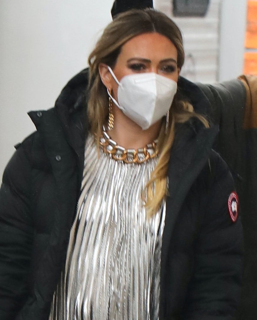 Hilary Duff accessorizes with long chain earrings and stays safe with a face mask