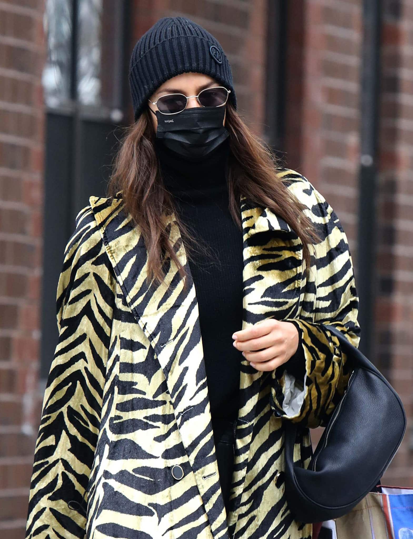 Irina Shayk accessorizes with Ruslan Baginskiy beanie, By Far bag, and Illesteva sunglasses