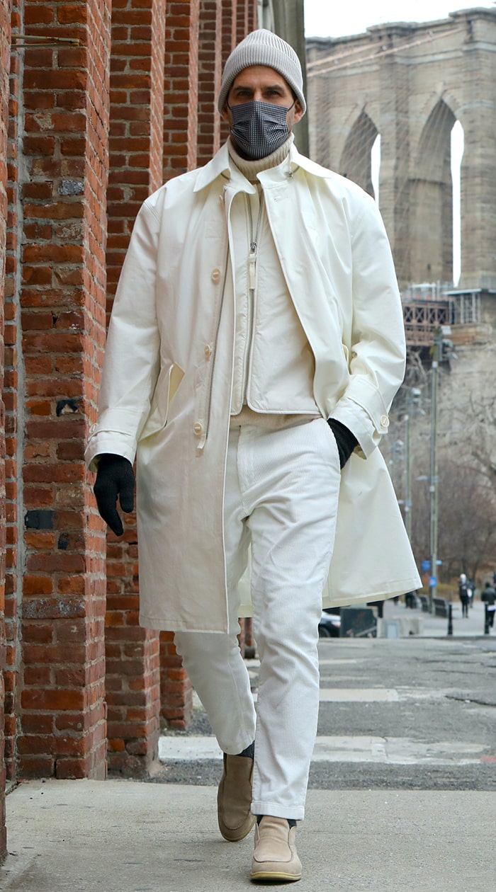 Johannes Huebl opts for an all-white winter outfit with a gray beanie and light brown shoes