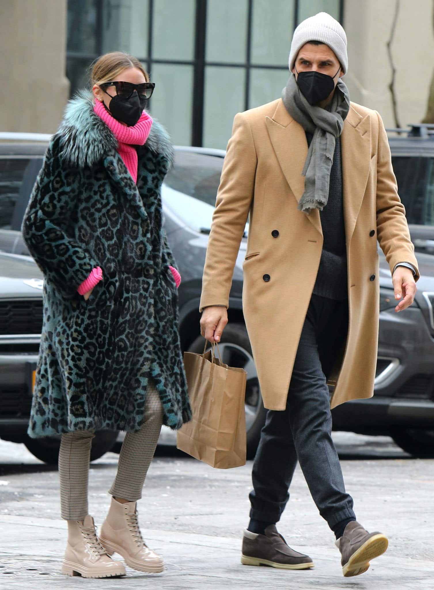 Johannes Huebl looks handsome in a tan coat with a gray sweater and a scarf