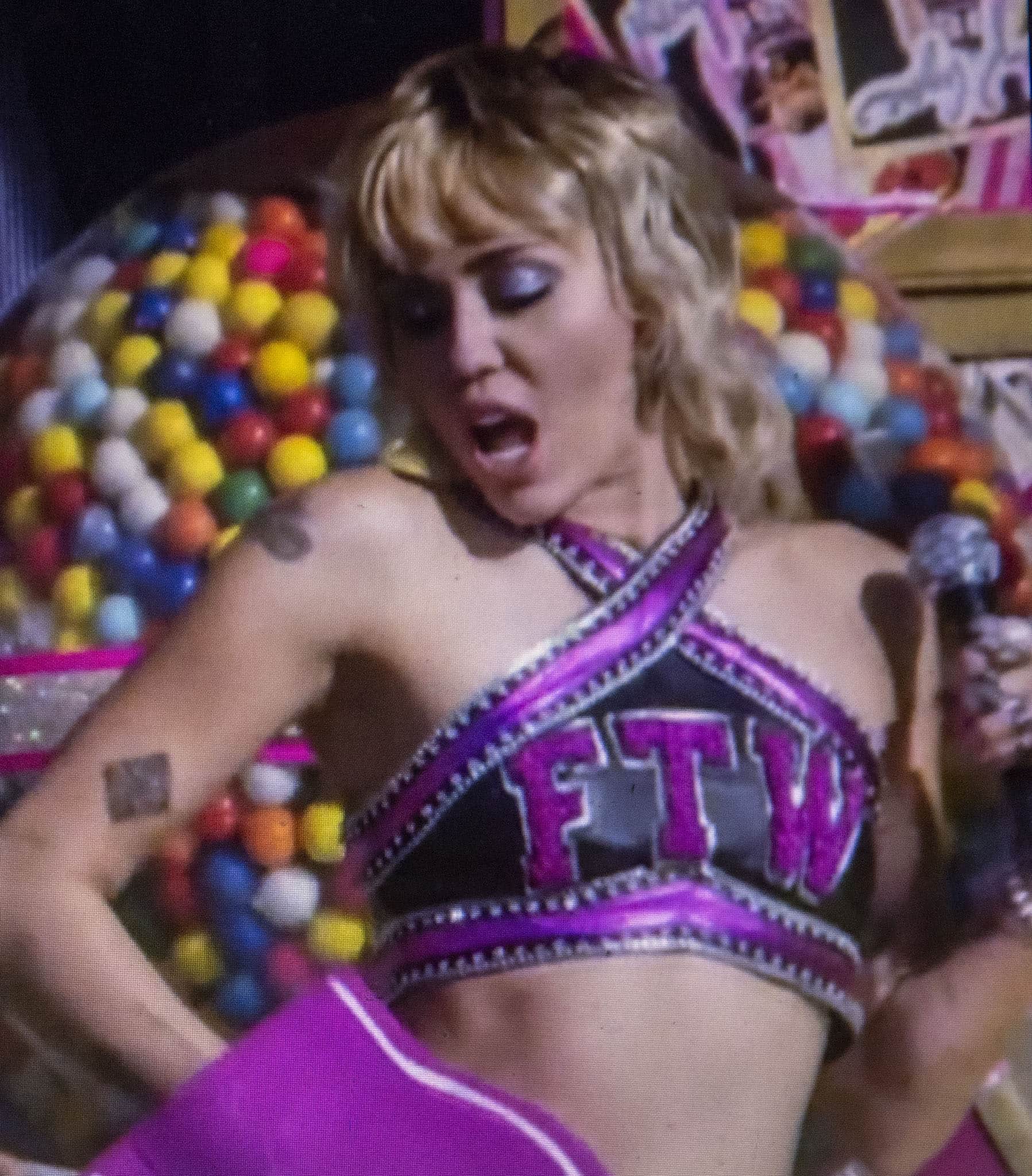 Miley Cyrus shows off her toned figure in a custom Michael Schmidt cheerleader outfit