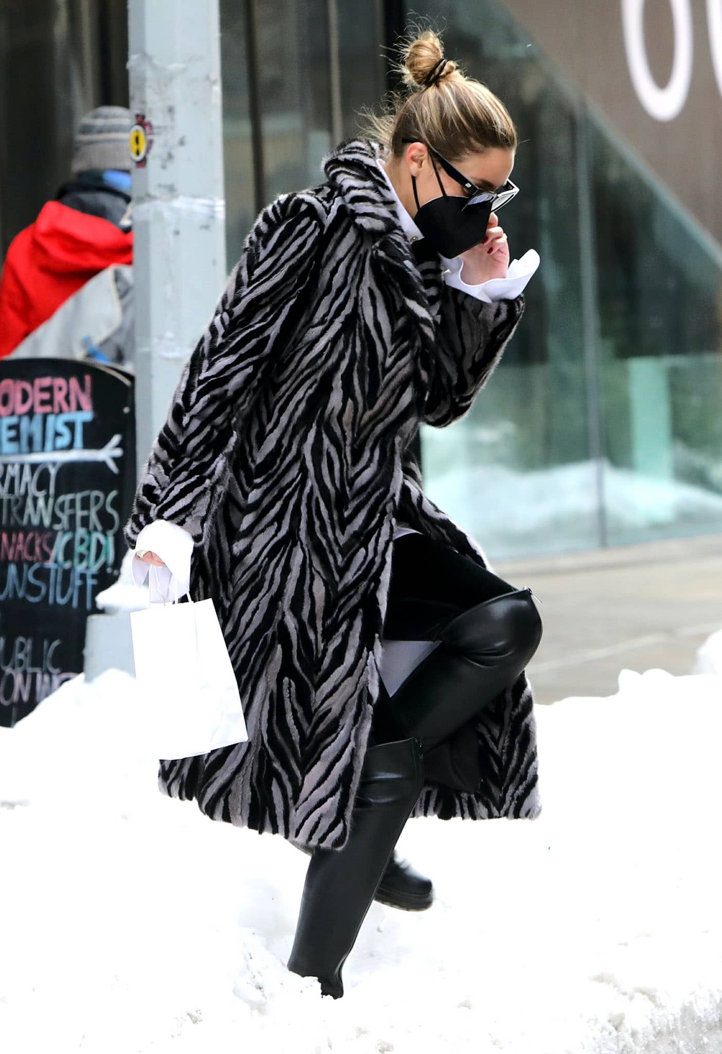 Olivia Palermo walks over a snow pile in Gianvito Rossi over-the-knee leather boots