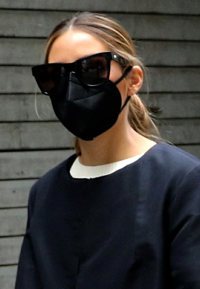 Olivia Palermo ties her hair back and stays safe with a black face mask