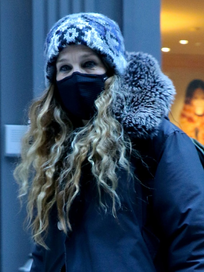 Sarah Jessica Parker bundles up in a black fur-trimmed coat and a patterned knit beanie