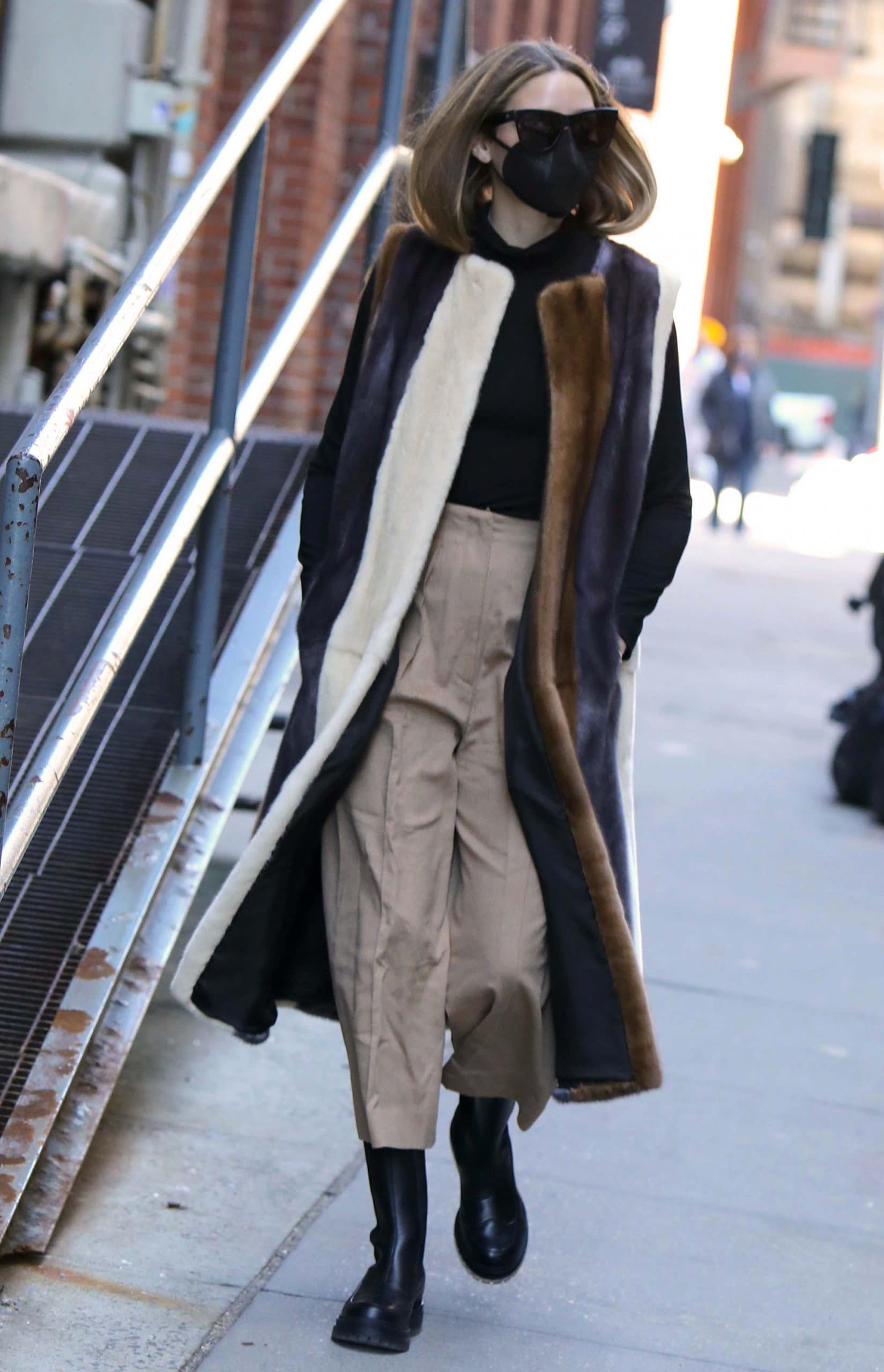 Olivia Palermo in a winter chic Pologeorgis faux fur striped vest, black turtleneck sweater, and khaki pants