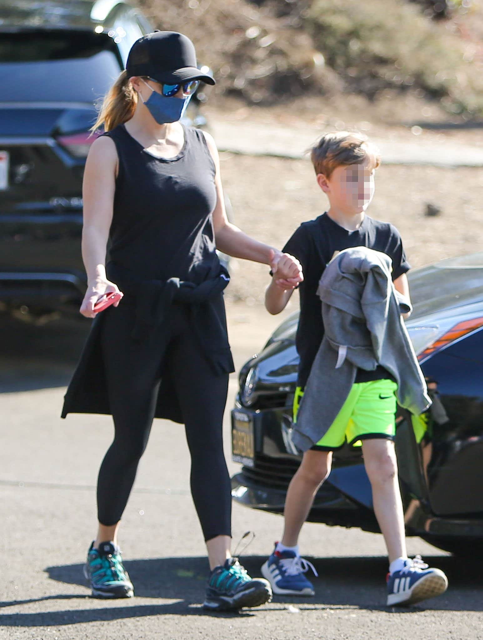 Reese Witherspoon's youngest son, Tennessee, wears a pair of electric green Nike shorts with Adidas sneakers