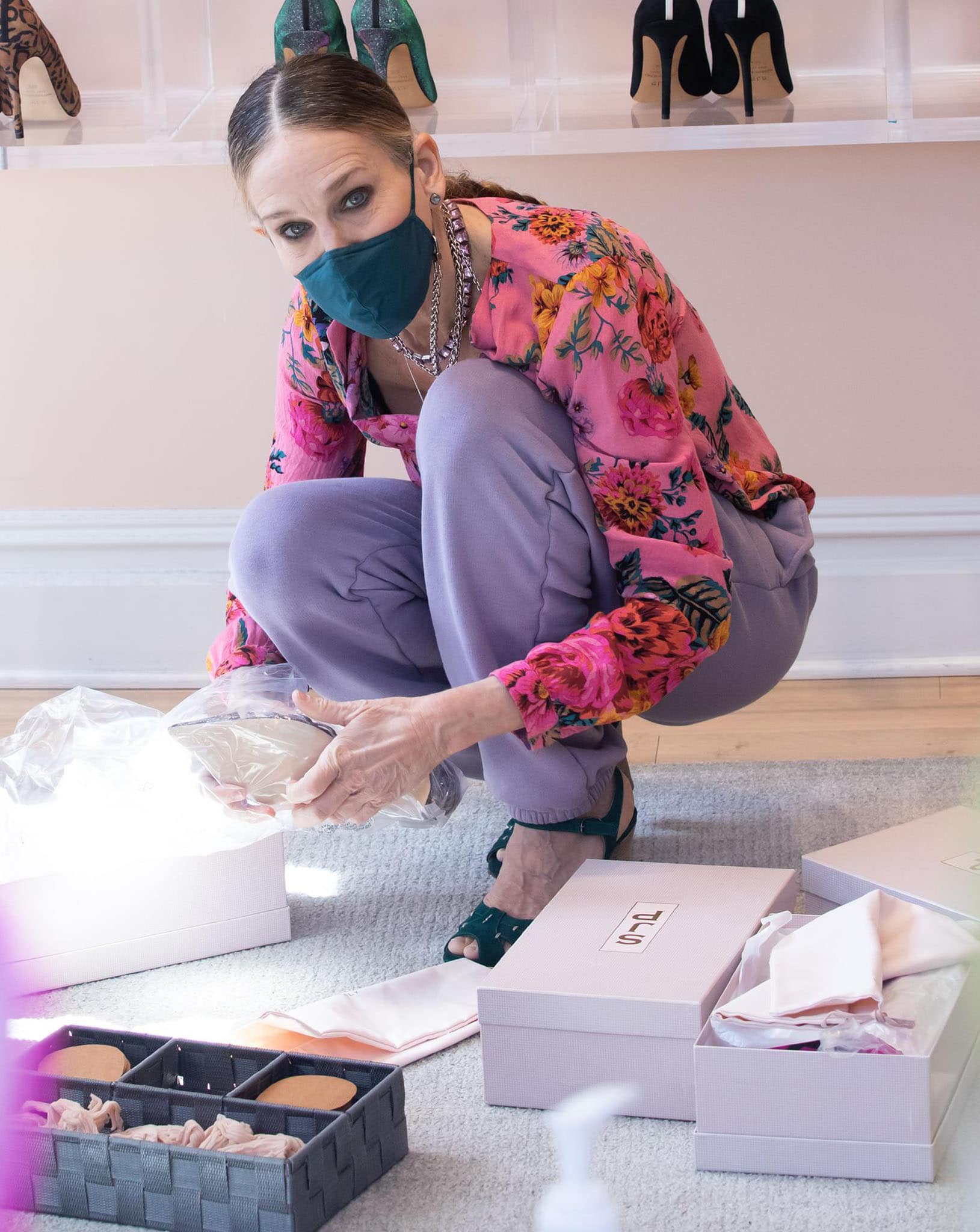 Sarah Jessica Parker wears a braided ponytail and styles her look with layered necklaces and a teal-colored face mask