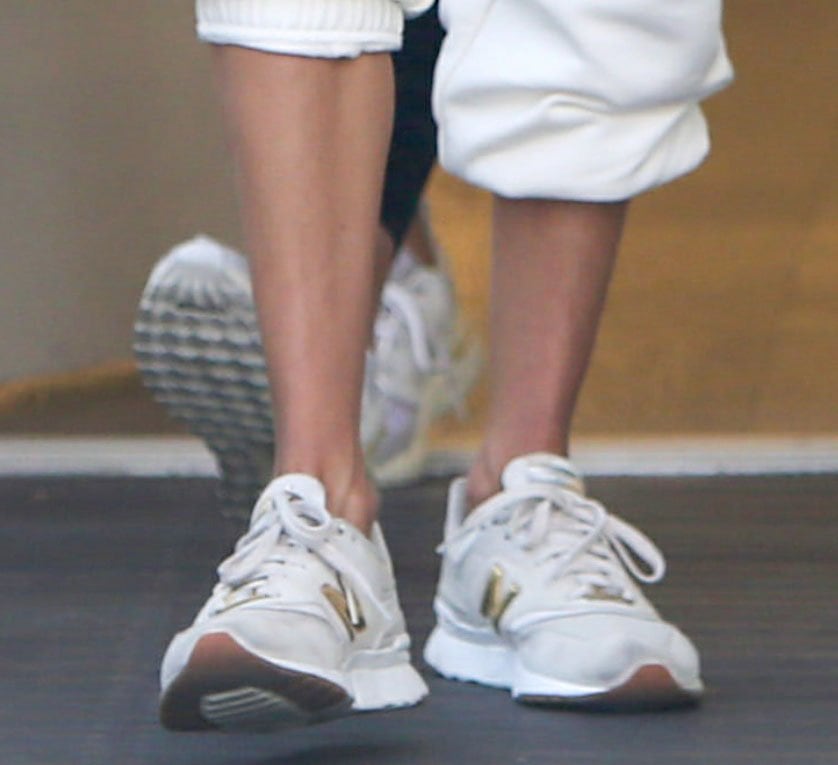 Alessandra Ambrosio completes an all-white sporty look with gray and gold New Balance 997H sneakers