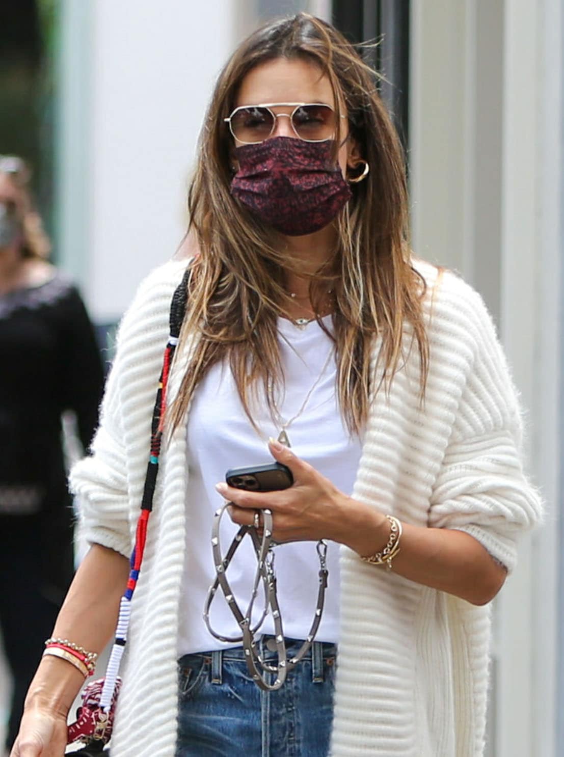 Alessandra Ambrosio looks fresh in a white tee with blue jeans and an off-white sweater