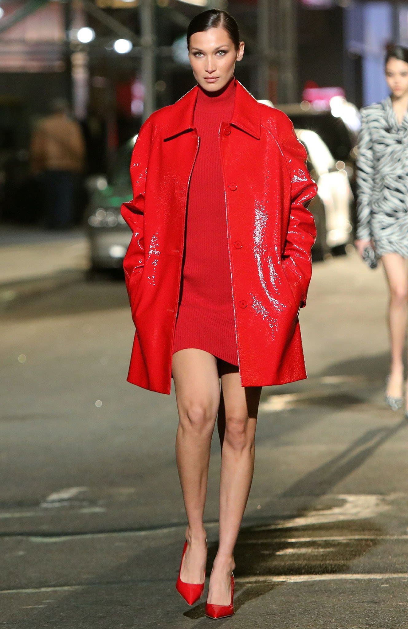 Bella Hadid bares her legs in a red mini dress and red PVC coat