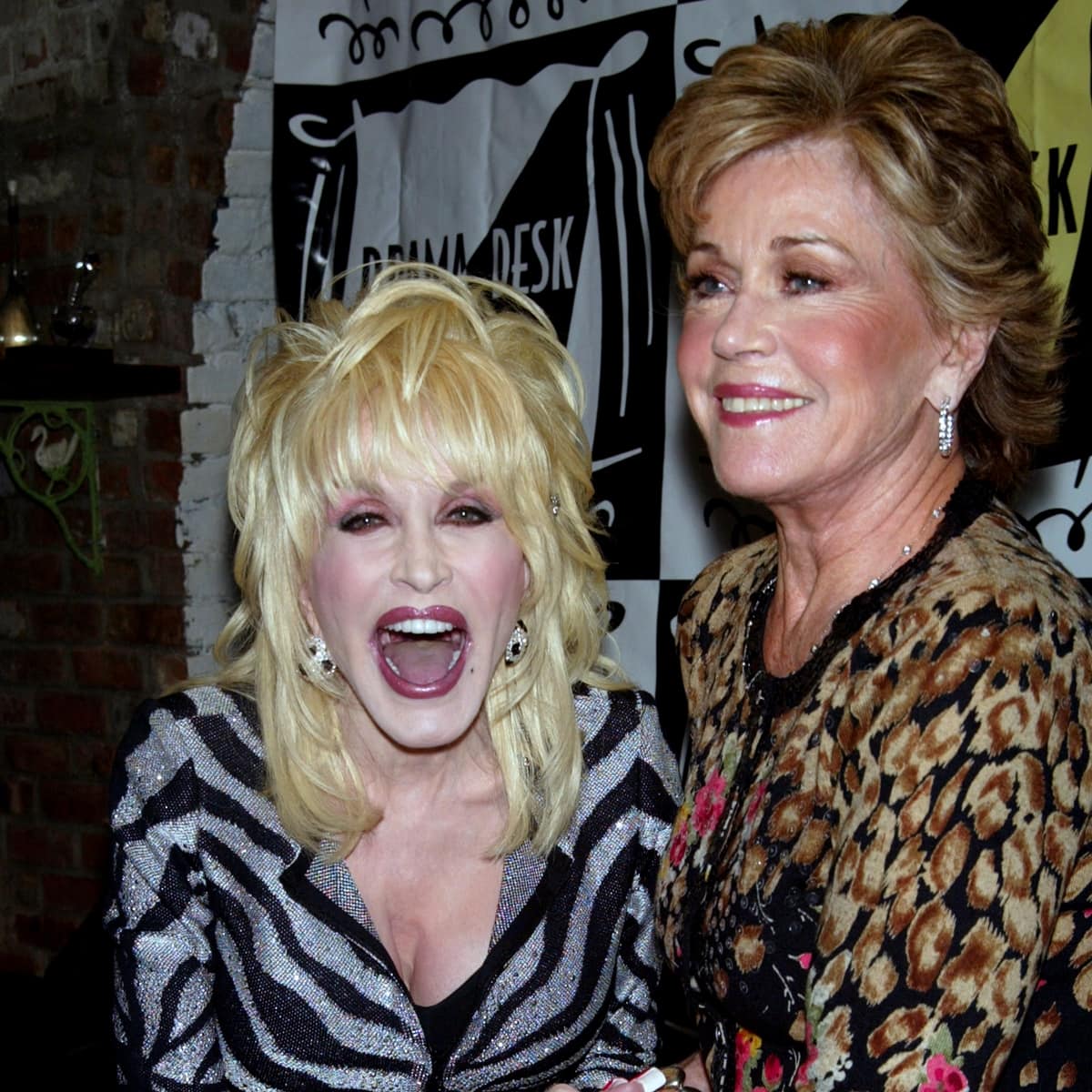 Dolly Parton and Jane Fonda share a joyful moment at a 2009 event, with Dolly sparkling in a bold zebra-print blazer and Jane exuding elegance in a chic leopard-print ensemble