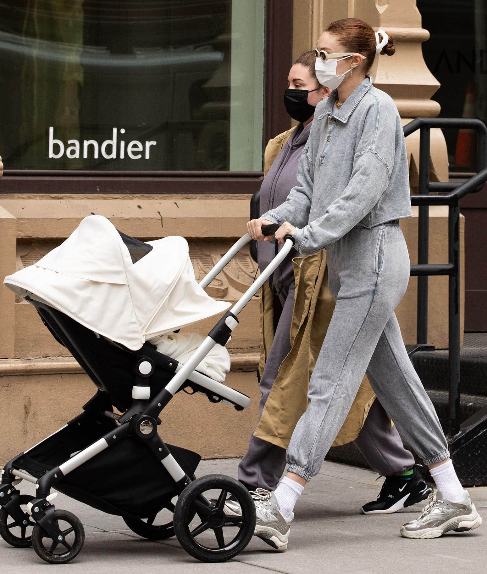 Gigi Hadid showcases cozy street style in a gray collared polo sweater and matching joggers while strolling with Khai in NYC on March 31, 2021