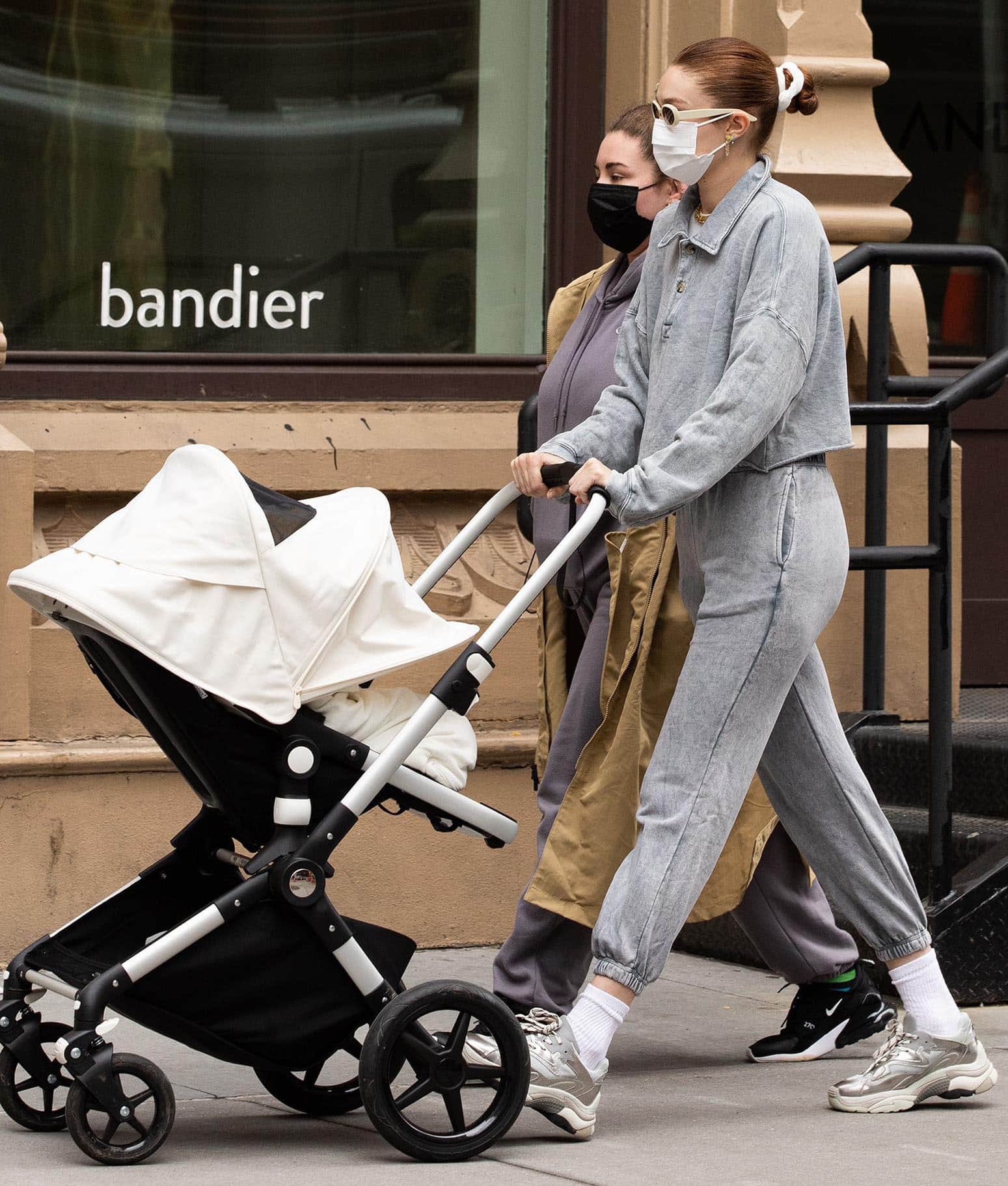 Gigi Hadid strolls with Khai in a gray polo sweater and matching joggers on March 31, 2021