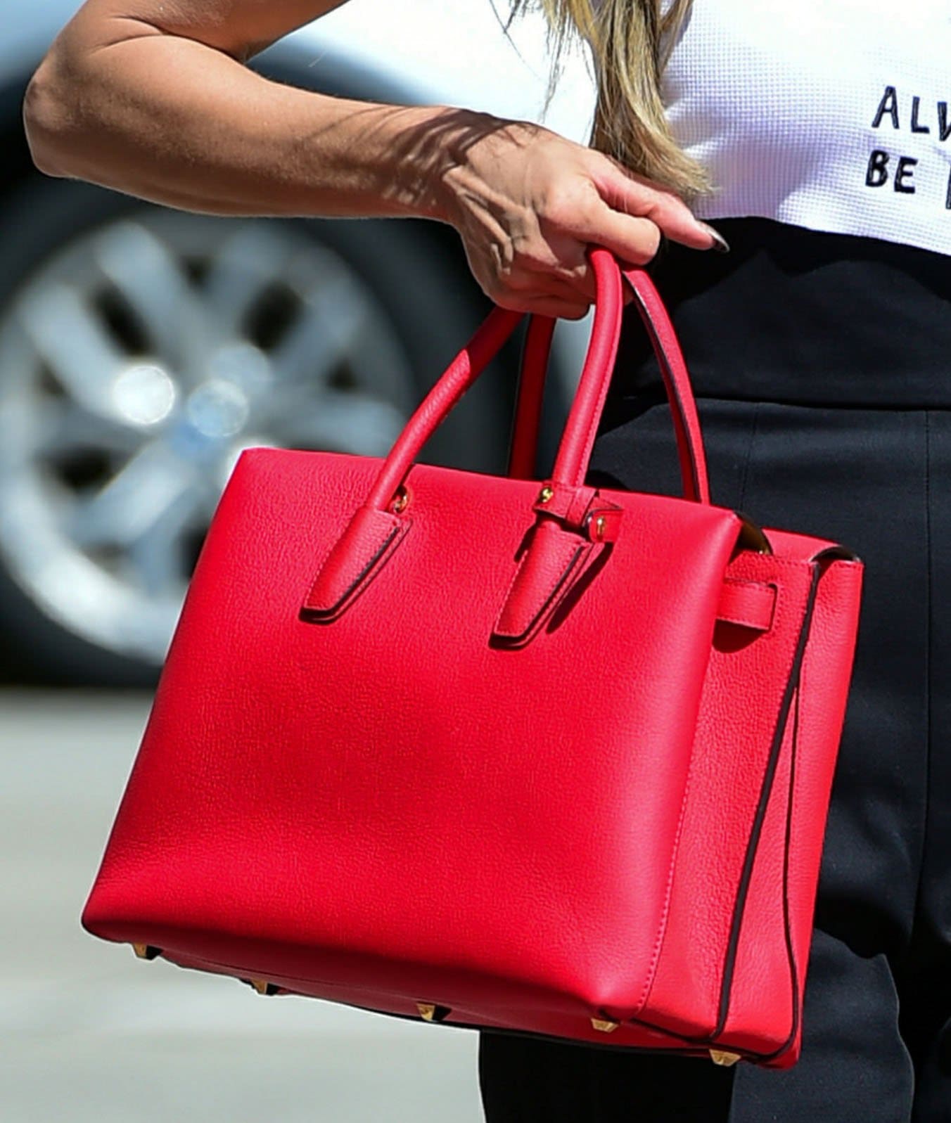 Heidi Klum adds color to her look with a ruby red MCM Milla tote bag