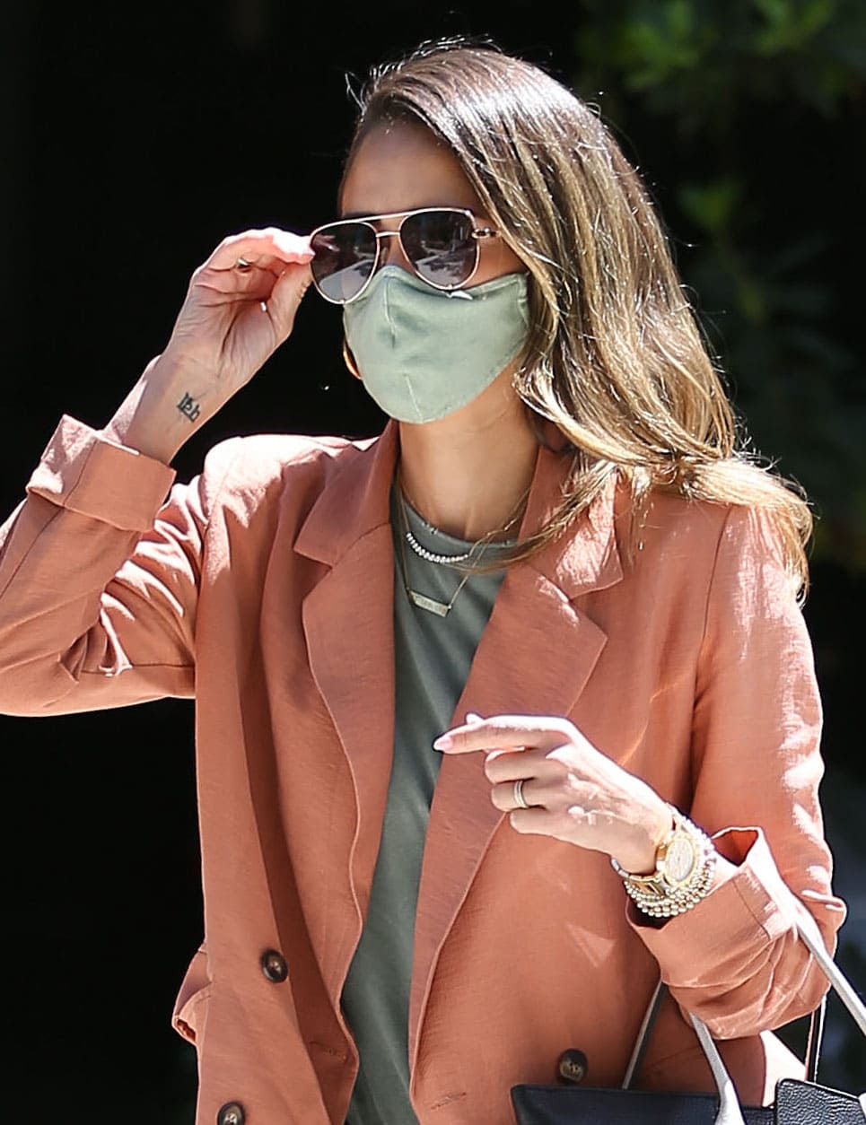 Jessica Alba wears her honey tresses down and covers her face with gold-framed sunnies and green face mask