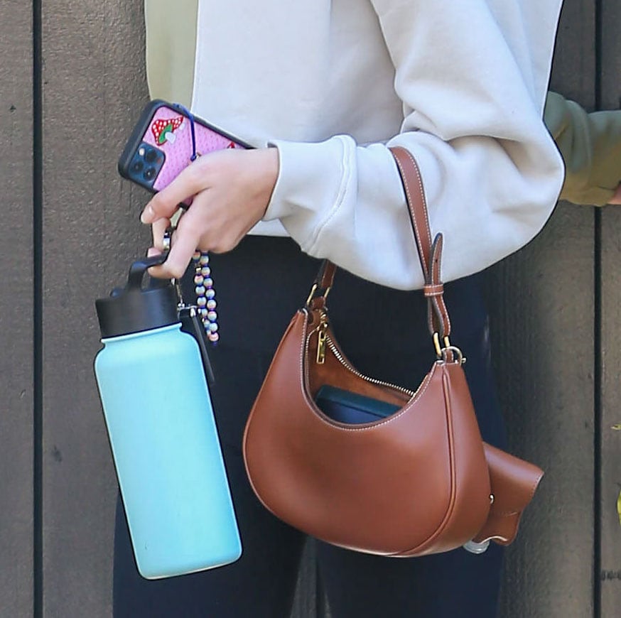 Kaia Gerber carries a Celine bag with Simple Modern Summit water bottle and her iPhone in Wildflower Shrooms phone case