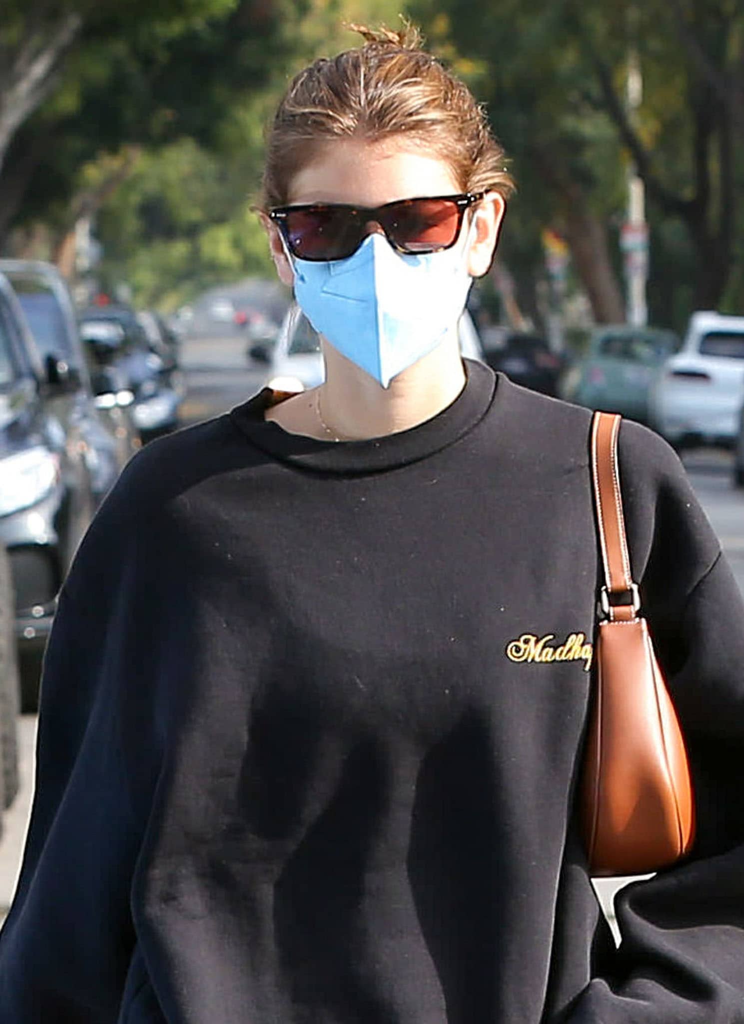 Kaia Gerber pulls her hair into a casual bun and hides her eyes behind The Row x Oliver Peoples BA CC acetate sunglasses